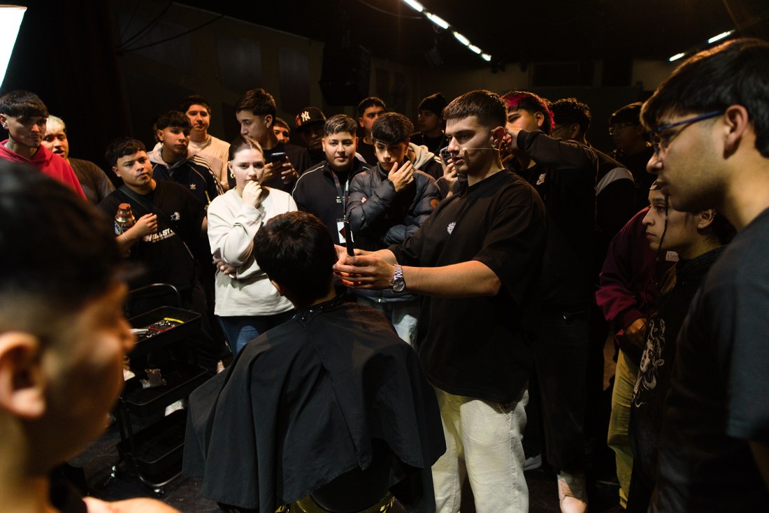 Marce LC cortando en vivo frente a la clase en un seminario presencial de Fade Masters